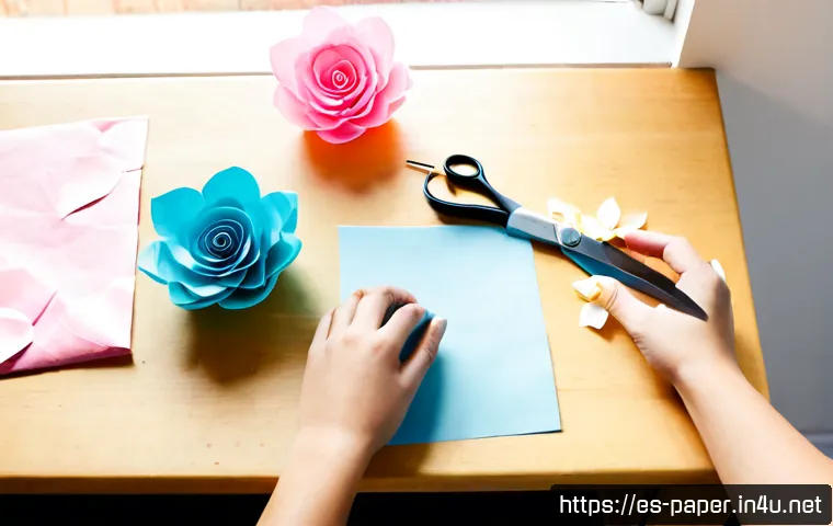종이꽃 장식 방법 - Photorealistic step-by-step paper flower decoration workspace, adult hands folding and shaping paste...